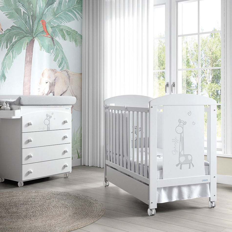 Berço Micuna Sabana 120x60 branco com girafa, num quarto de bebé com cômoda e decoração de selva.