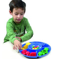 Menino a utilizar a bandeja de separação Miniland azul para organizar contas e formas por cor, promovendo a aprendizagem estruturada.