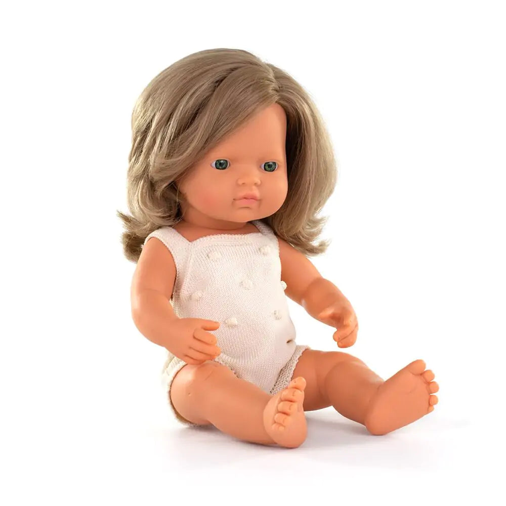 Boneca bebé Miniland caucasiana loira de 38cm, sentada, com cabelo louro e olhos azuis, vestindo um body branco.