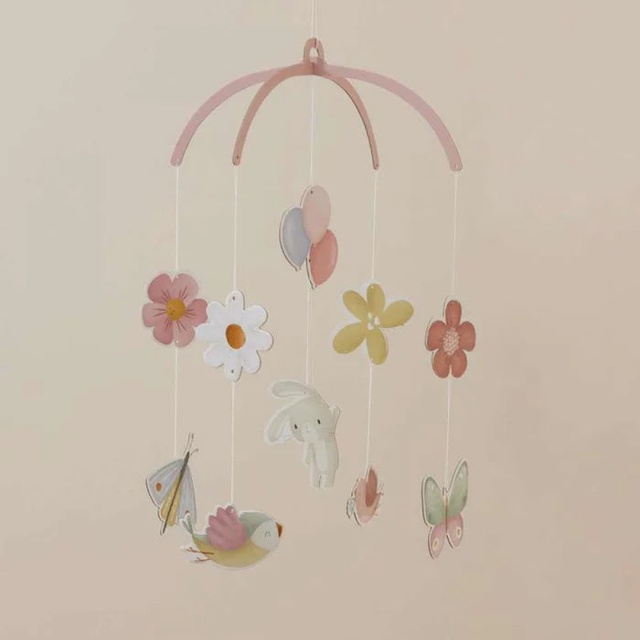 Móbile de berço Little Dutch com 10 figuras de cartão, incluindo flores e animais, pendurado e em rotação suave contra um fundo rosa claro.