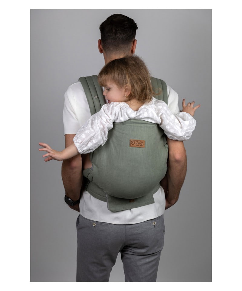 Pai transporta uma criança mais velha nas costas com a mochila Isara ELITE Ajustável Sage Green Linen, mostrando o ajuste para criança grande.