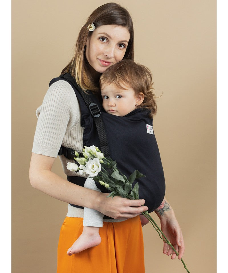 Mulher a usar a mochila Isara Toddler Preschooler Noire com uma criança na posição frontal, vista frontal.