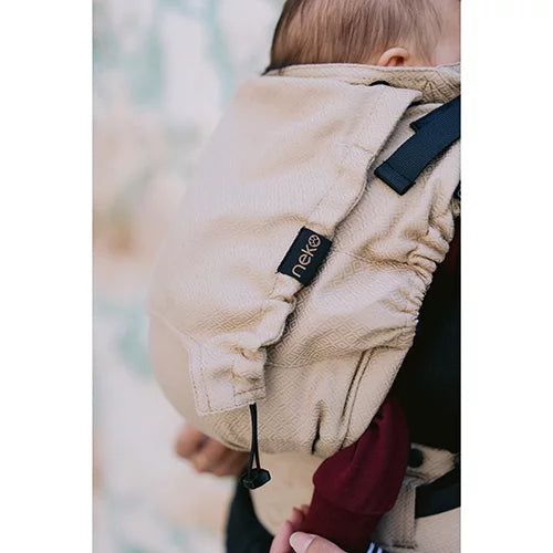 Imagem da mochila Neko sendo usada por uma mãe, com um bebé recém-nascido posicionado corretamente na frente, demonstrando a ergonomia.