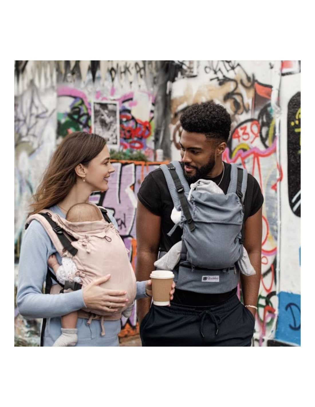 Homem e mulher a usar o porta-bebés Quokkababy E-Carrier Denim Blue numa posição frontal.