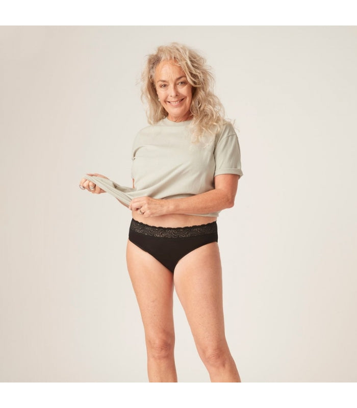 Modelo usando a cueca menstrual Modibodi preta de cintura alta, mostrando o ajuste confortável e discreto.