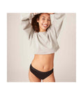 Modelo usando cueca menstrual Modibody preta, sorrindo e mostrando o conforto do produto.