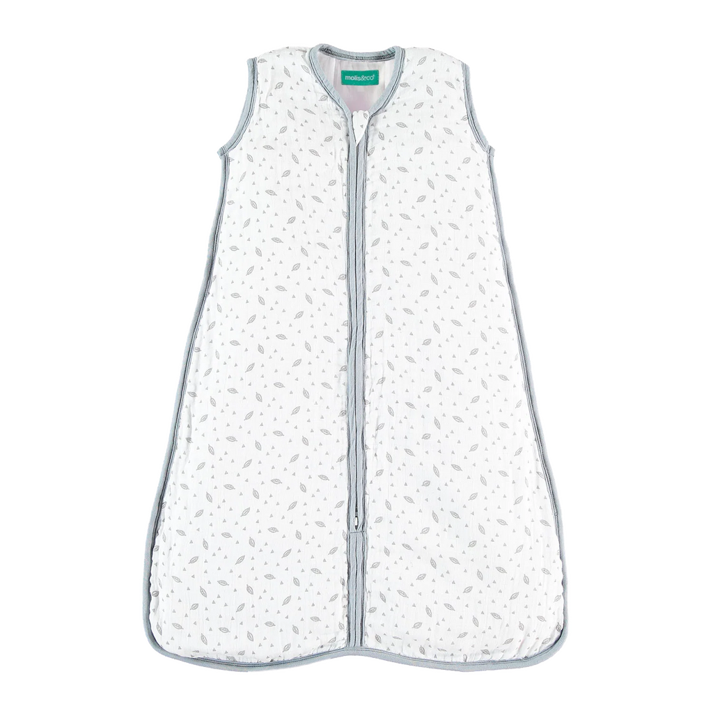 Saco de dormir MolisandCo TOG 1.0 em musselina de algodão branco com padrão de folhas cinzentas e fecho central.