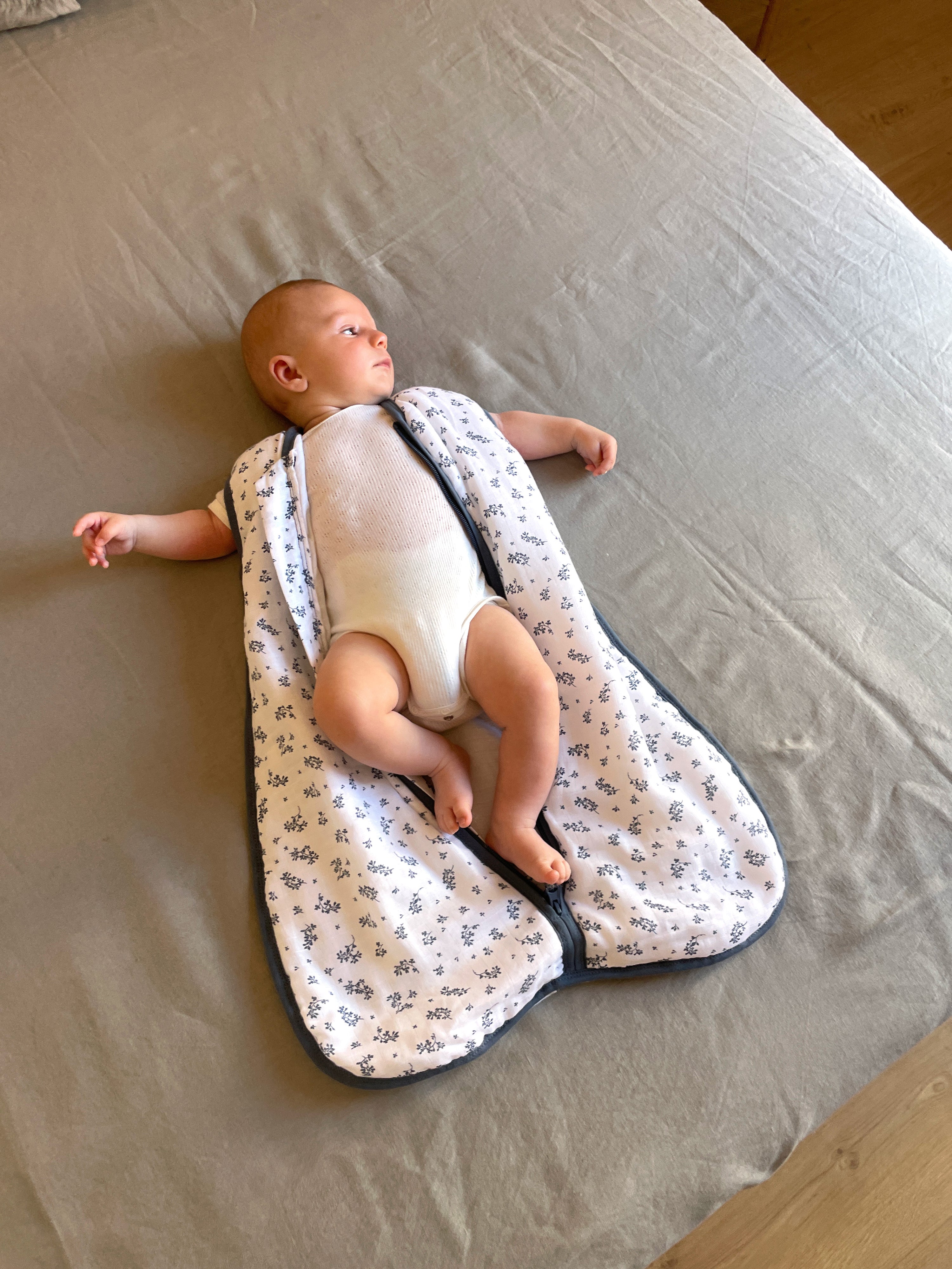 Bebé no saco de dormir MolisandCo TOG 1.0, algodão musselina, aberto, mostrando conforto e design.