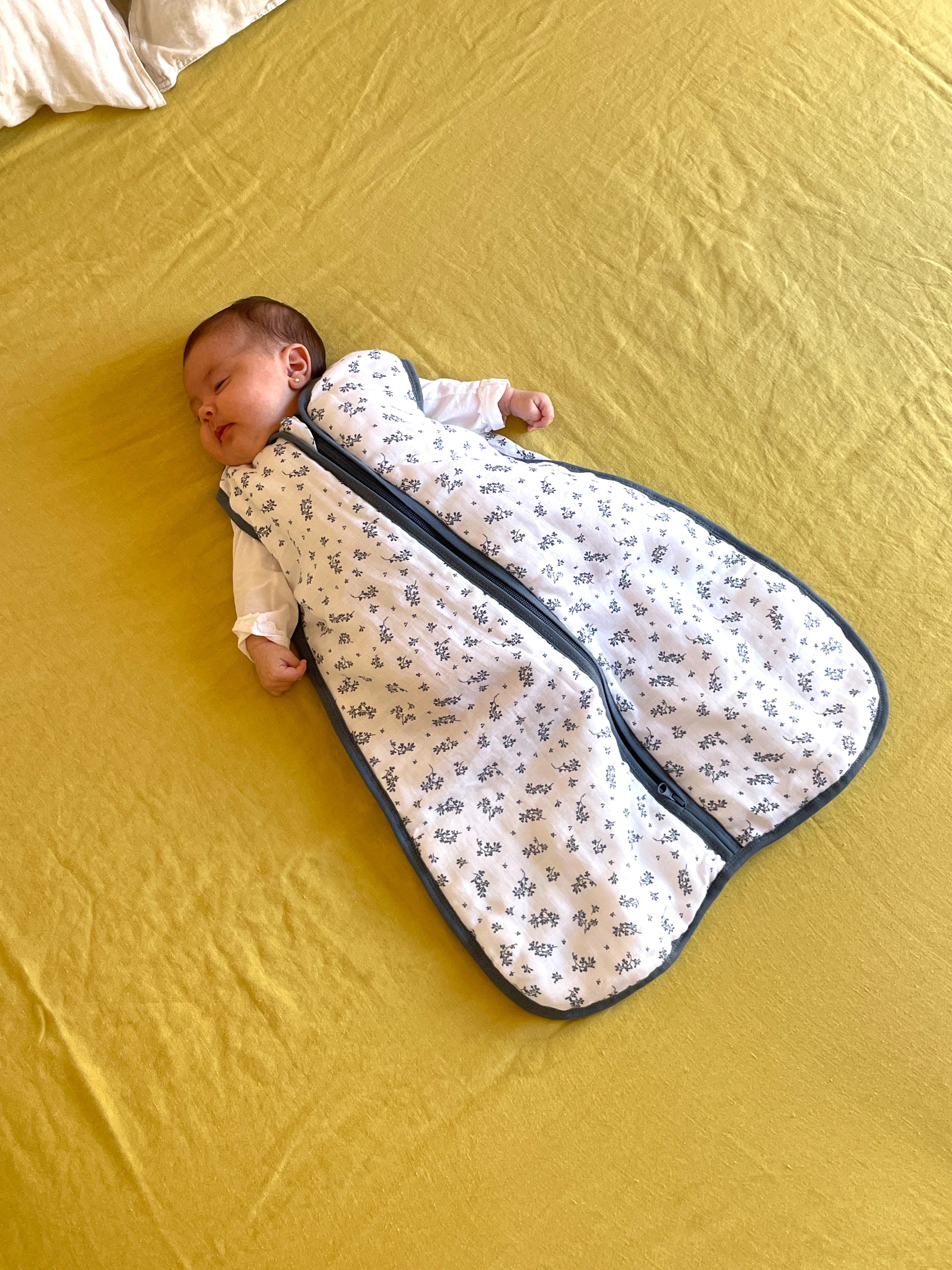 Bebé a dormir serenamente no saco de dormir MolisandCo TOG 1.0, algodão musselina, padrão floral.