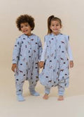 Duas crianças, um menino e uma menina, sorridentes, vestindo o saco de dormir MolisandCo TOG 2.5 com pés e mangas, padrão "Winter Animals".