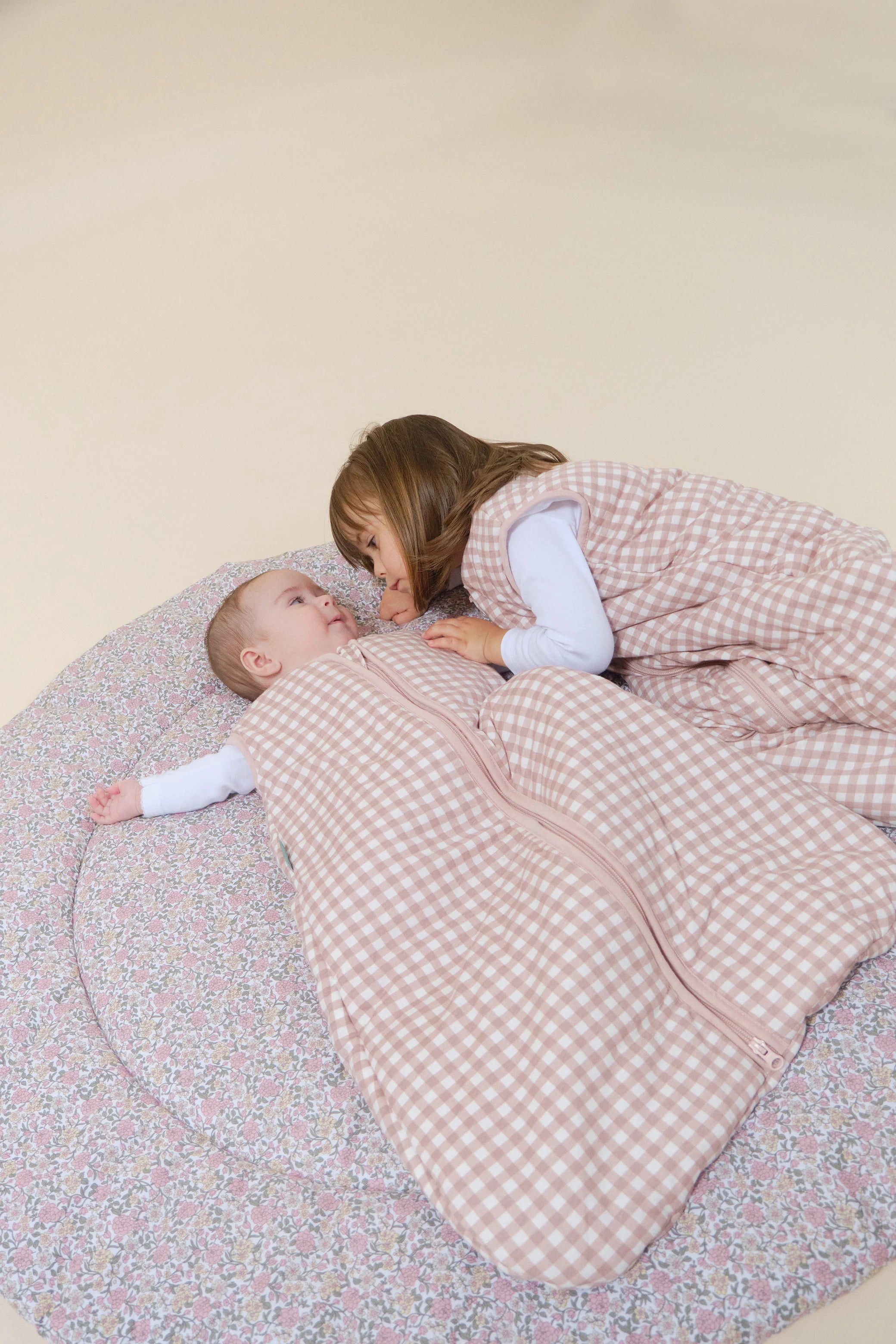 Bebé em saco de dormir MolisandCo TOG 2.5 Dusty Rose xadrez com criança mais velha. Conforto e segurança.