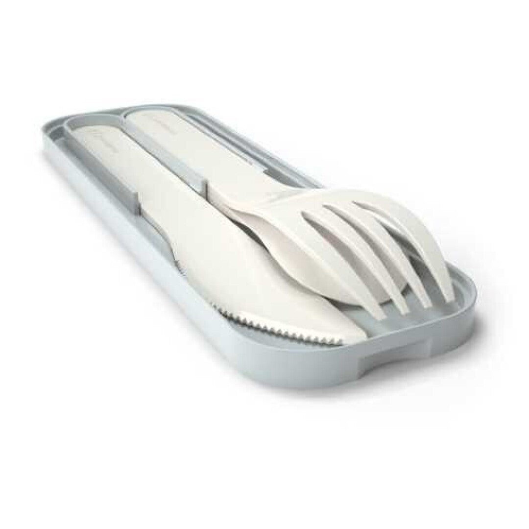 Conjunto de talheres infantis Monbento brancos (faca, garfo, colher) guardados no estojo de transporte cinza claro.