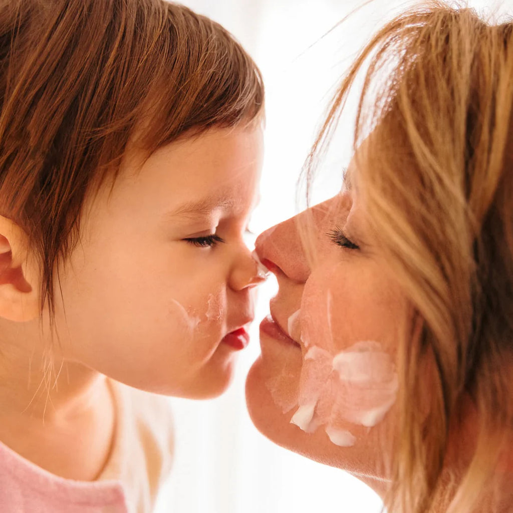 Mãe e filho partilhando um momento de carinho com o creme Monjour aplicado no rosto.