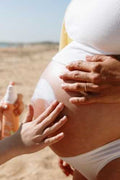 Grávida aplicando protetor solar Monjour SPF 50+. Seguro para grávidas e bebés a partir de 1 ano.