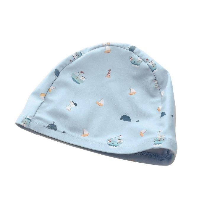 Touca de natação infantil Monnëka azul-claro com padrão de barcos, baleias e faróis, vista de cima.