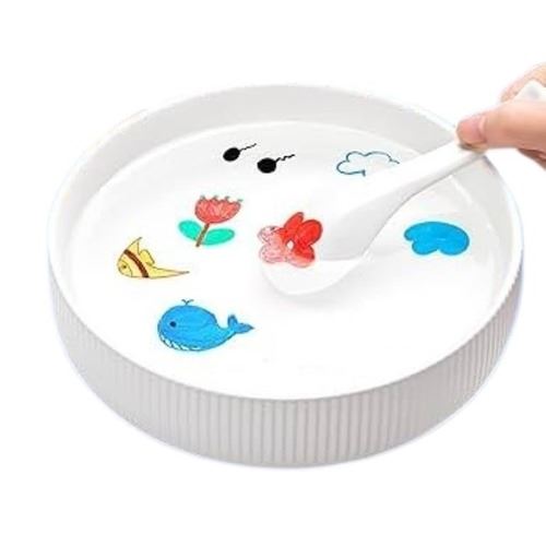 Desenhos coloridos de uma baleia e flores feitos com os marcadores Moxy a flutuar na superfície da água numa taça branca.