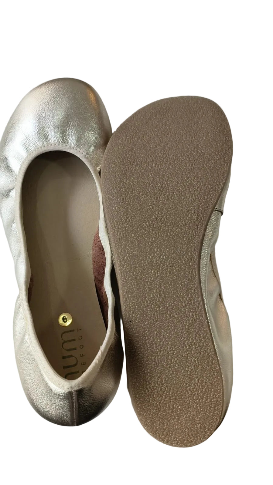 Vista superior de um sapato Mum Barefoot aberto, mostrando a palmilha com o logótipo e o outro sapato virado, expondo a sola flexível de borracha termoplástica.
