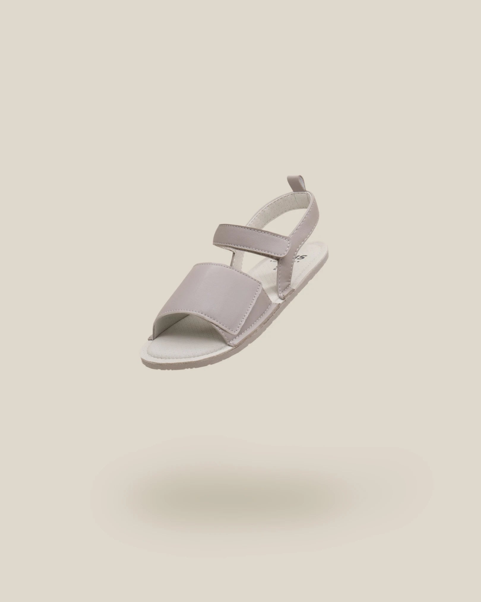 Sandália barefoot infantil Muris Barefoot Rome Mini Taupe, modelo em tom taupe com fecho em velcro e sola fina flexível. Design leve, respirável e respeitador da anatomia do pé.

