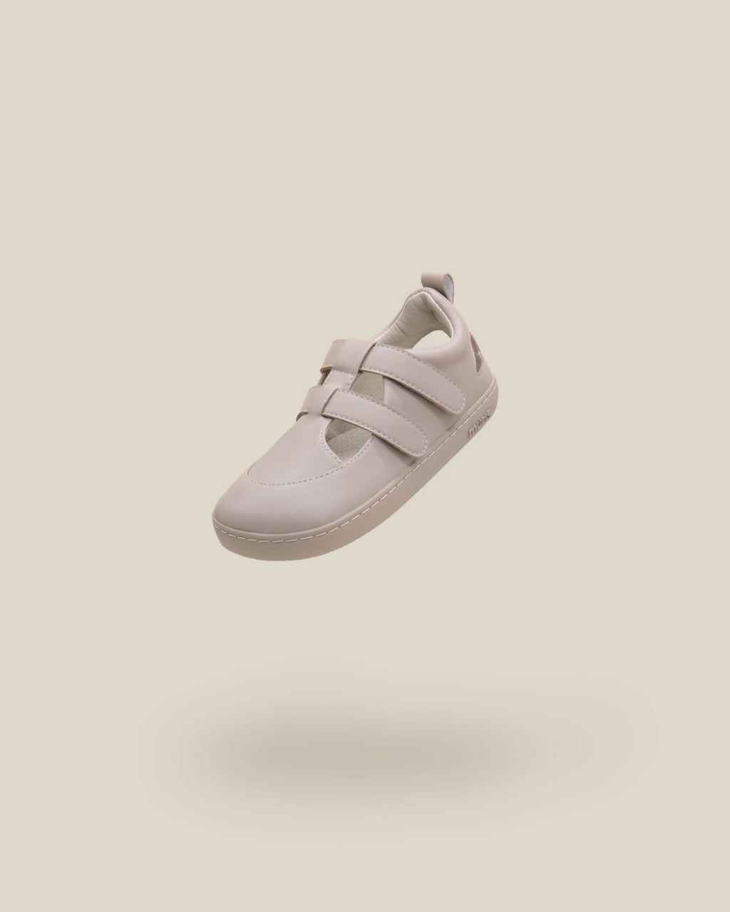 Sandália fechada Muris Fiji Mini em tom taupe, estilo barefoot, com fecho de velcro duplo, apresentada em voo sobre fundo neutro.