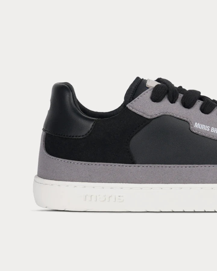 Close-up do calcanhar e lateral da sapatilha Muris Majorca Black, destacando o material, o logótipo "muris" gravado na sola e a ausência de contraforte.