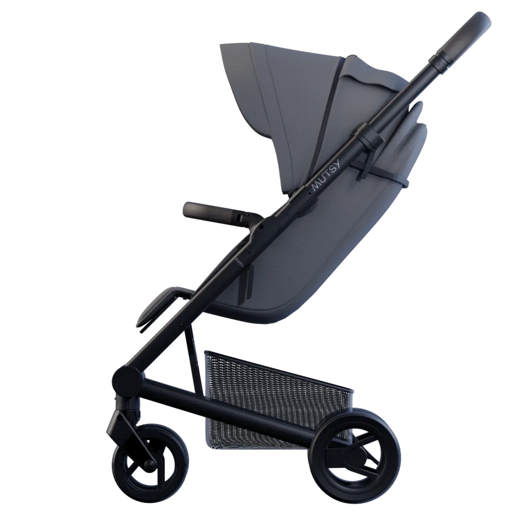 Carrinho de passeio Mutsy Nexo cinzento escuro, visto de perfil, destacando o design compacto e o chassis preto.