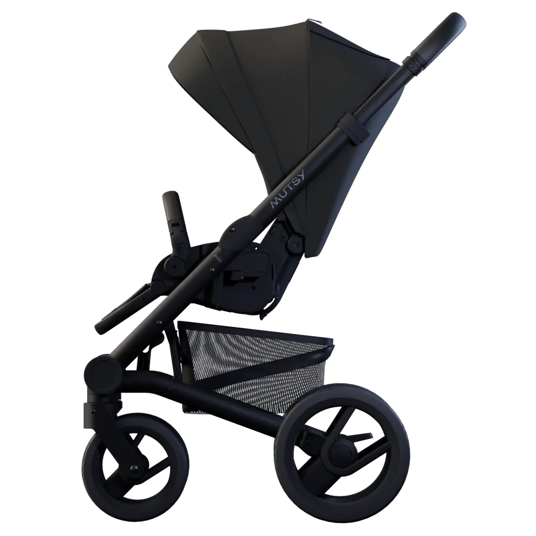Mutsy Nio carrinho de passeio preto, vista lateral completa, enfatizando a estrutura leve e o cesto de arrumação inferior.
