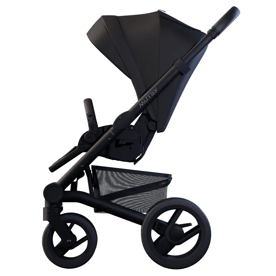 Vista lateral do carrinho de passeio Mutsy Nio em preto, destacando o chassis robusto, as rodas grandes e o guiador ajustável com logótipo Mutsy.