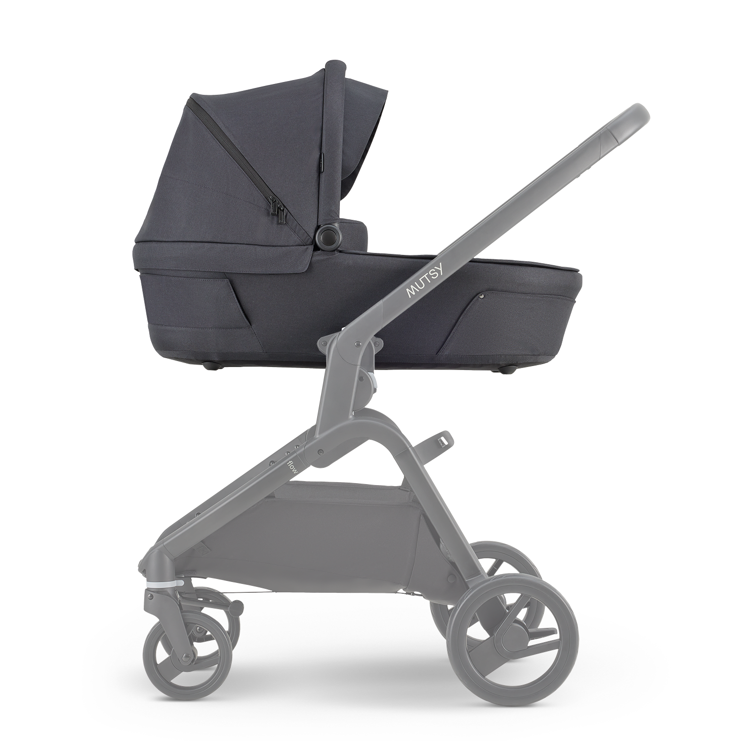 Alcofa Mutsy Flow em cor escura (North Black) montada no chassis cinzento, vista lateral, destacando o design moderno.