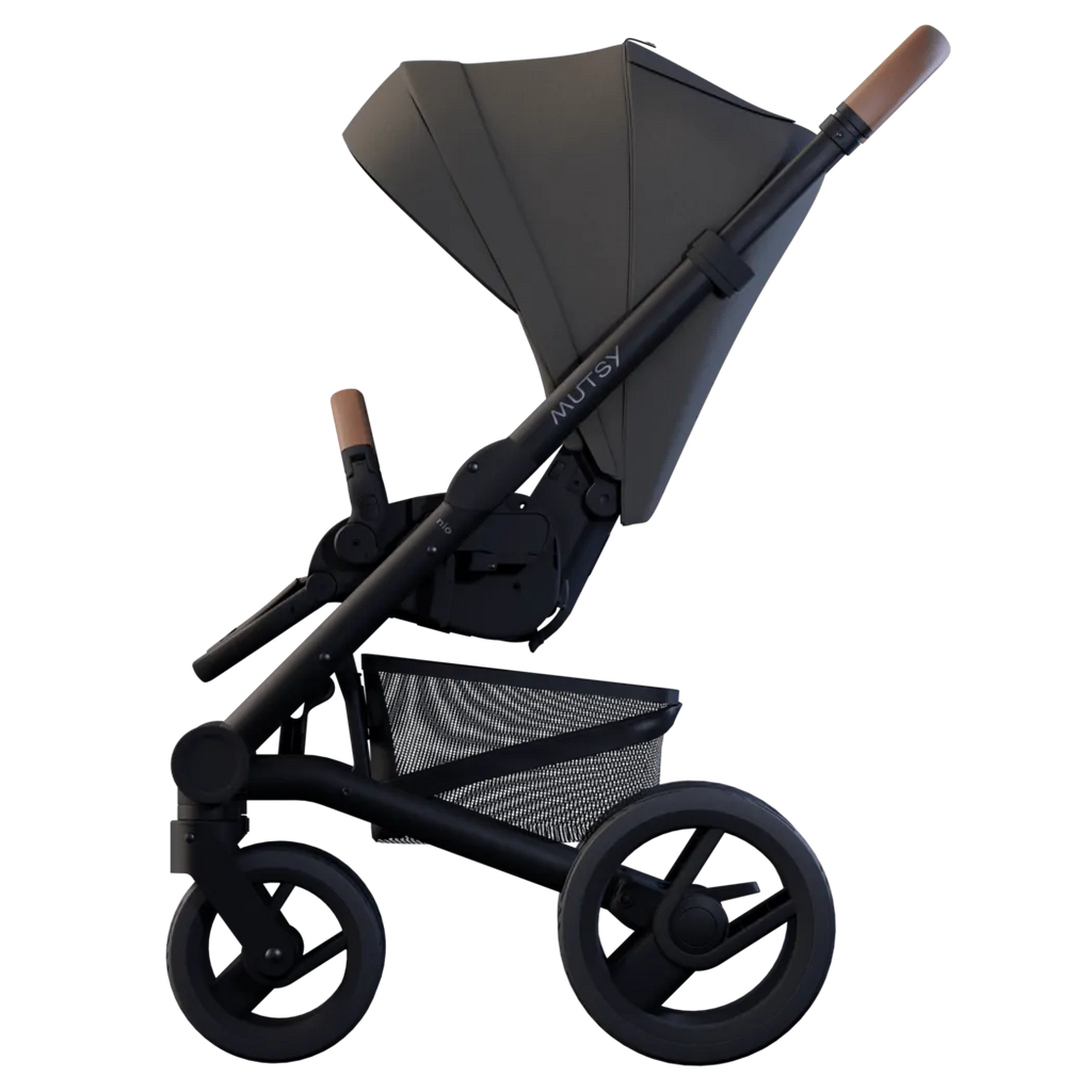Carrinho Mutsy Nio com assento, perfil lateral inclinado, guiador com detalhe em pele castanha, evidenciando a ergonomia do assento.