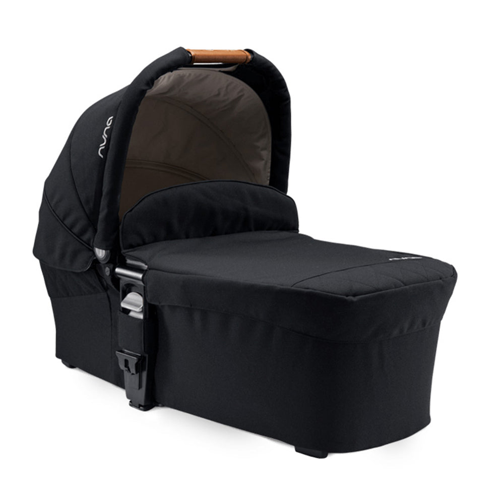 Alcofa Nuna MIXX NEXT preta, vista lateral, com capota aberta e alça de transporte em couro sintético.