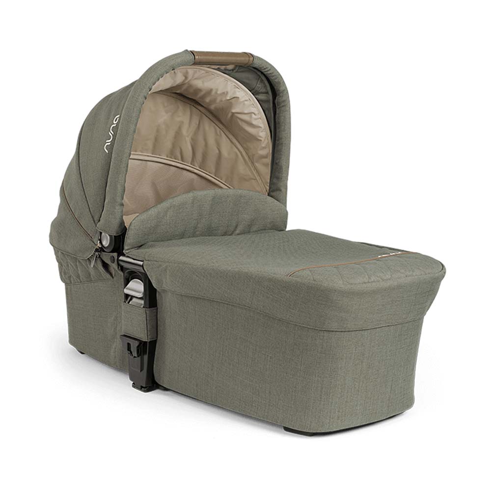Alcofa Nuna MIXX NEXT em tecido verde-azeitona, com capota aberta, destacando a alça de transporte em castanho.
