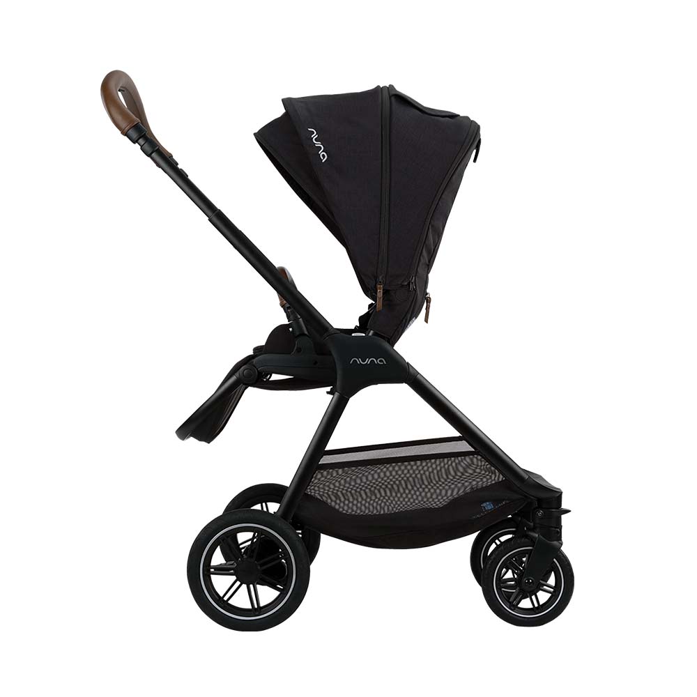 Carrinho de passeio Nuna TRIV NEXT preto, visto de lado, com capota estendida e alça em couro sintético castanho.