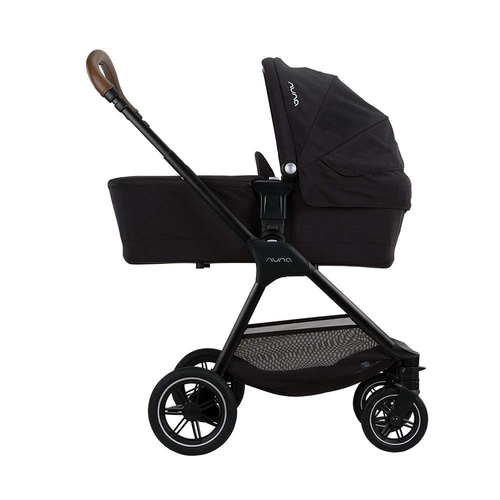 Carrinho Nuna TRIV NEXT preto configurado com alcofa, ideal para recém-nascidos, visto de perfil.