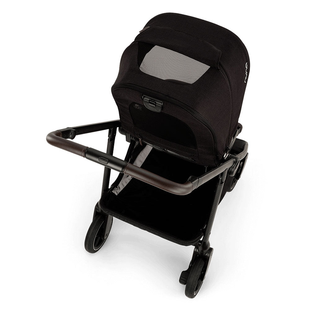 Vista superior do carrinho Nuna SWIV 360 Caviar, destacando o assento reversível, manípulo em pele sintética e capota com rede de ventilação.