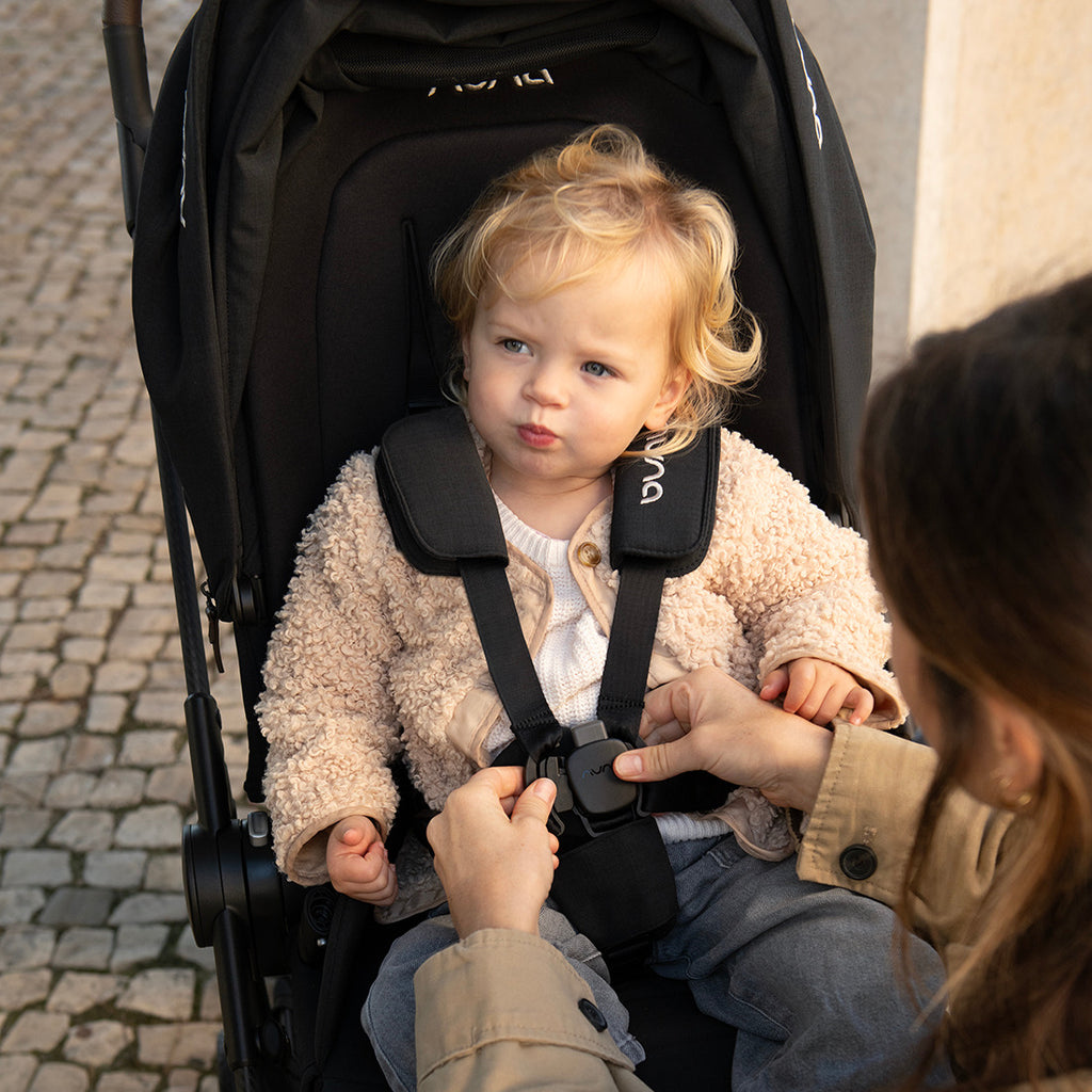 Carrinho Nuna IXXA NEXT com assento virado para o mundo, mostrando as grandes rodas com suspensão.