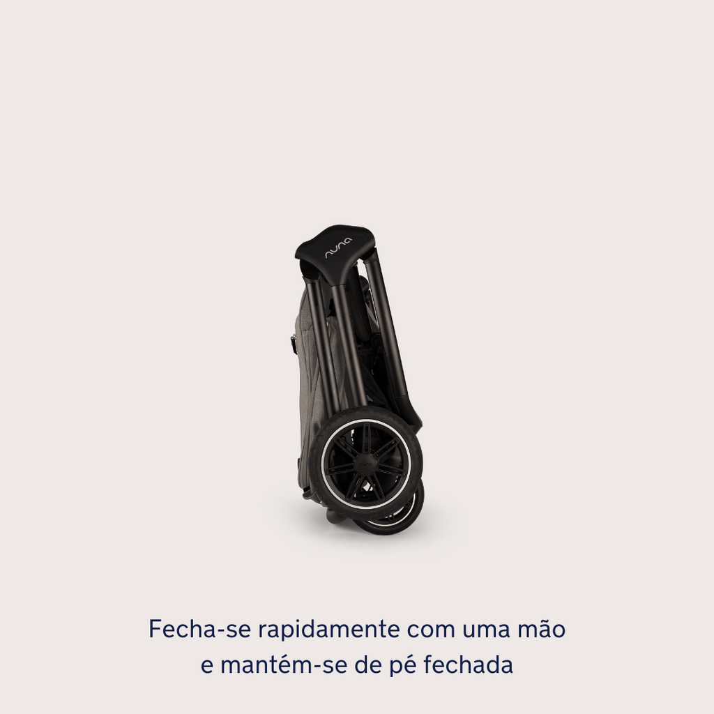 Carrinho Nuna TRIV NEXT compacto na cor Caviar, dobrado e de pé sozinho, demonstrando a facilidade de arrumação.