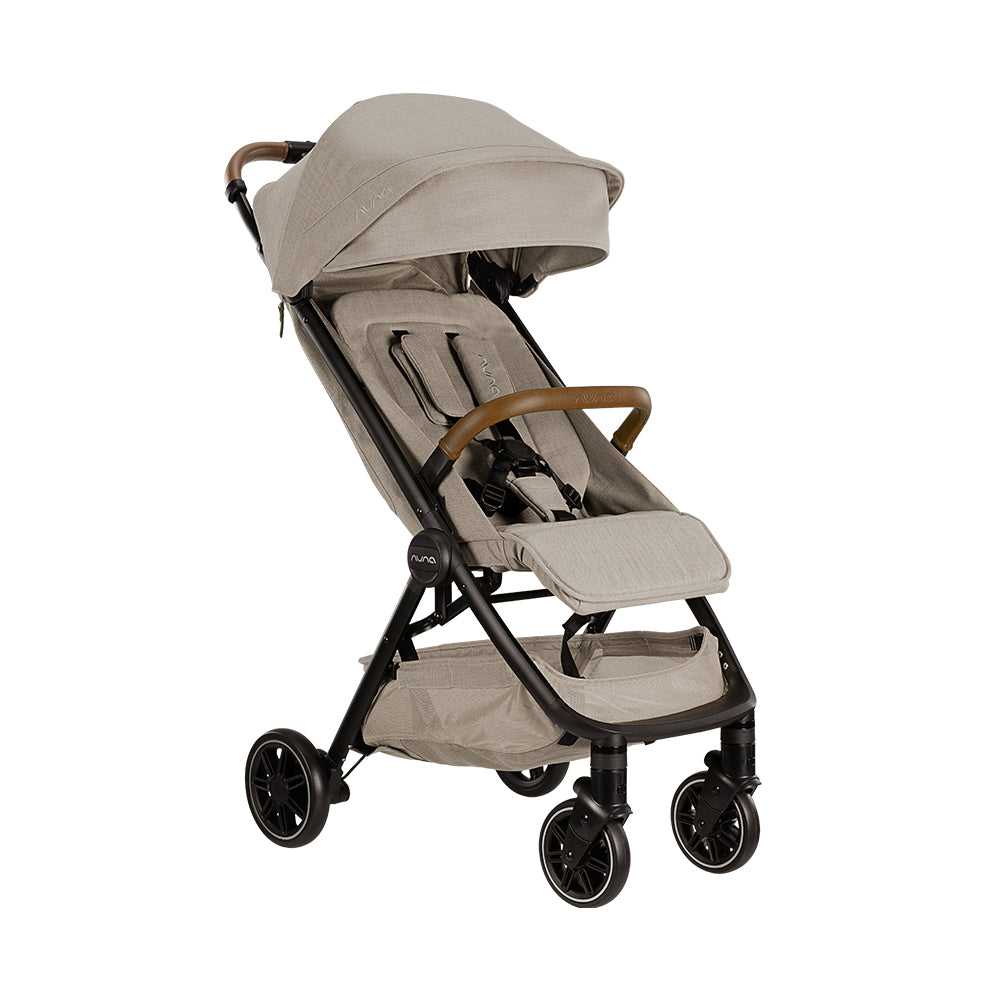 Carrinho de passeio Nuna TRVL bege, visto de lado, com guiador e barra de segurança em imitação de pele castanha, ideal para viagens.