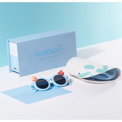 Óculos de sol infantis Sunsun, apresentados numa caixa com acessórios. Modelo leve e resistente, com proteção UV, ideal para proteger os olhos das crianças com estilo e segurança.