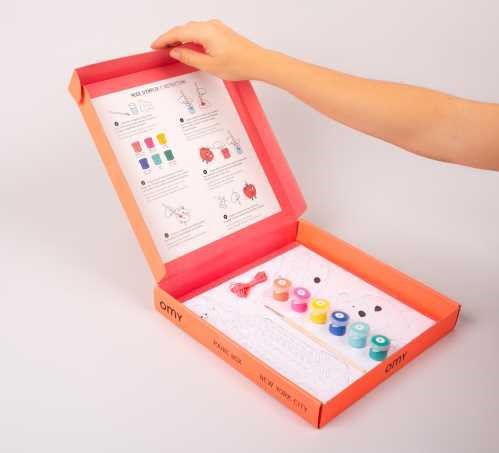 OMY Caixa para colorir New York aberta, mostrando as tintas, pincel, desenhos e instruções de pintura por números.