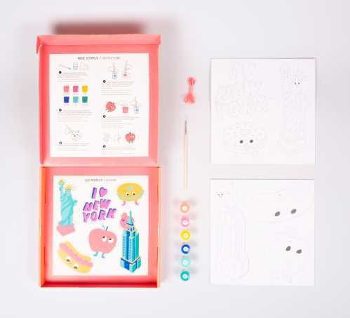 Vista geral do conteúdo da OMY Caixa para colorir New York, incluindo tintas, pincel, desenhos e instruções.