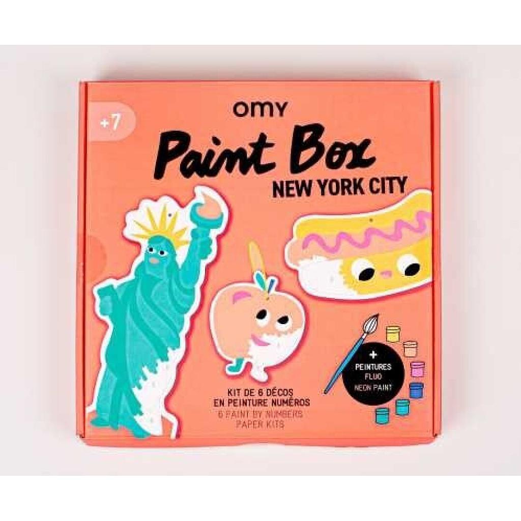Caixa OMY Paint Box New York City, com ilustrações da Estátua da Liberdade, maçã e cachorro-quente, indicando +7 anos.