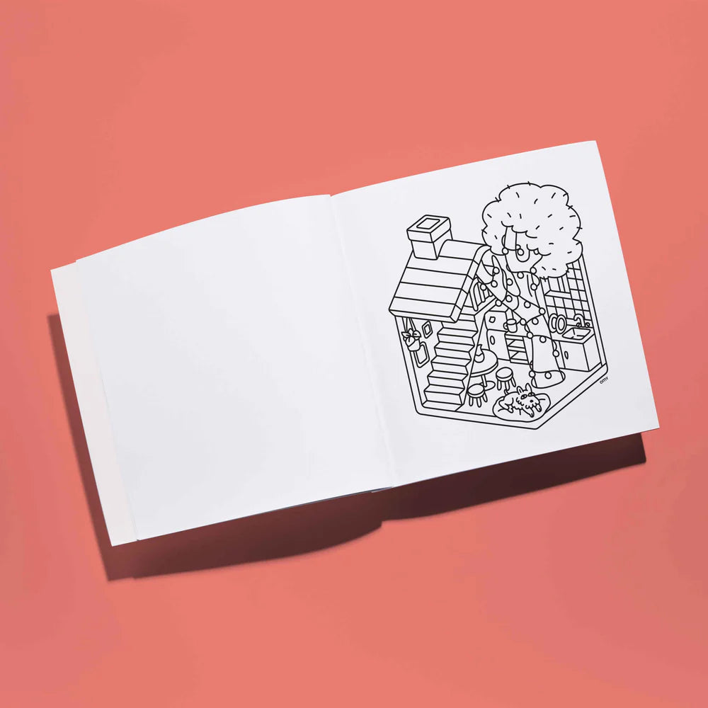 Interior de um caderno de colorir OMY aberto, mostrando uma página em branco à esquerda e uma ilustração de uma casa com árvore para colorir à direita.