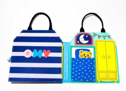 OMY Livro Play Kit Montessori aberto, mostrando a atividade de identificar letras e alimentos.