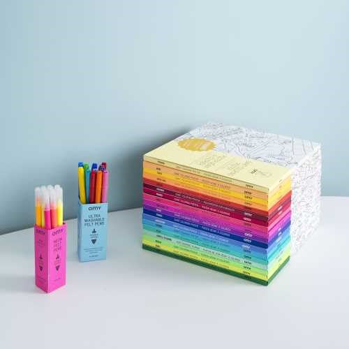 Conjunto de vários pósteres OMY Magic empilhados, ao lado de um conjunto de marcadores coloridos da marca OMY.