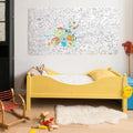 Poster gigante da OMY pendurado numa parede num quarto infantil.