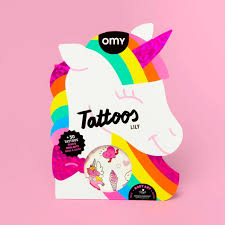 Embalagem de tatuagens temporárias OMY com o formato da cabeça de um unicórnio em tons de rosa, arco-íris e branco, exibindo a marca OMY e o nome "Lily Tattoos".