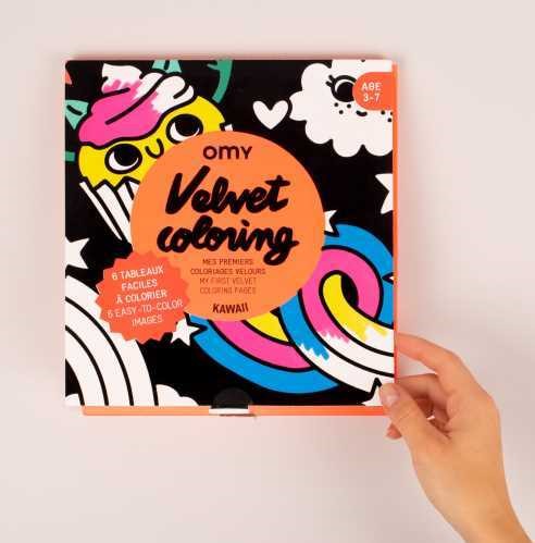 Capa do livro OMY Velvet Coloring com desenhos coloridos e aveludados, mostrando uma mão a segurar o livro.