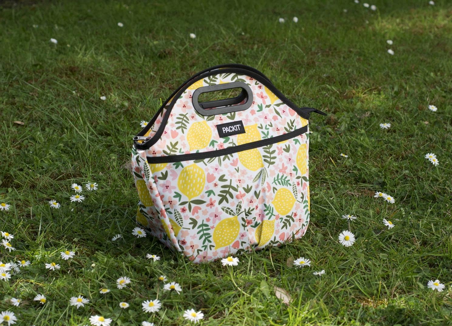 Bolsa lancheira Packit com fecho de correr, destacando a asa de transporte e o design compacto com padrão limões.