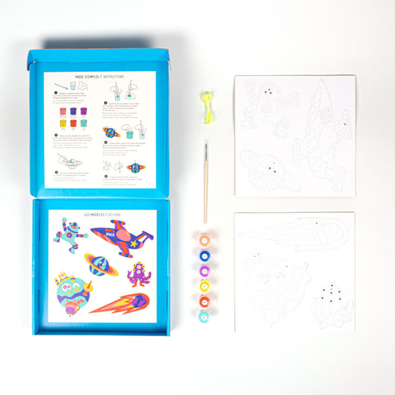 Conteúdo completo da caixa OMY Cosmos: tintas, pincel, cordão, instruções e decorações em cartão para colorir.