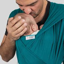 Pai beija ternamente o bebé enrolado no pano elástico Isara TANBOOCEL BAMBOO cor verde-azulado (Teal Green).